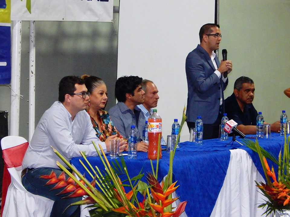 Viceministro Mora hablando durante un evento de la Carrera Chirripó, acompañado por otros representantes en la mesa principal.
